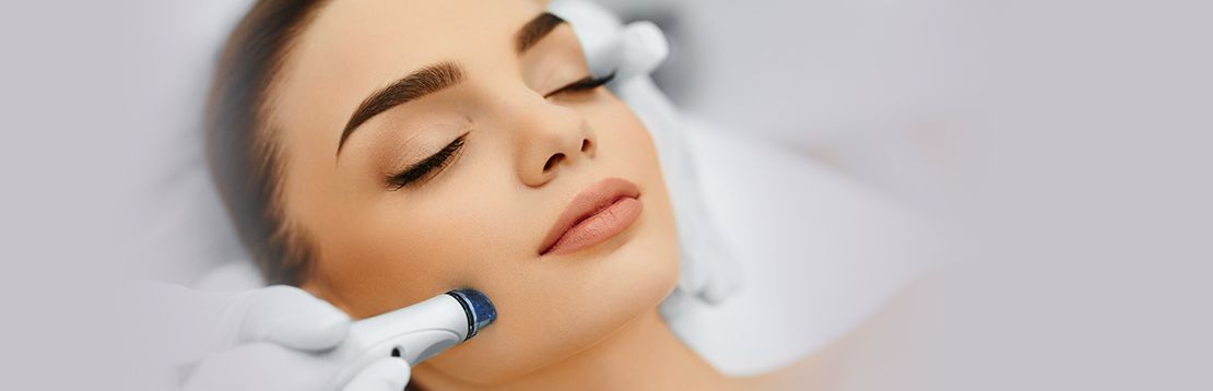 model smiling and applying spa treatments