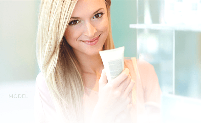 smiling blonde holding medical spa product