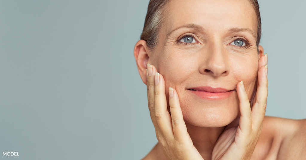 A mature woman, touching her face (model)